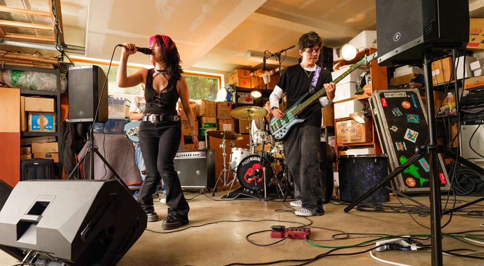 Grupo ensayando en un garaje con dos Mackie ThRash V2 en tr&iacute;pode y uno tumbado como monitor de suelo