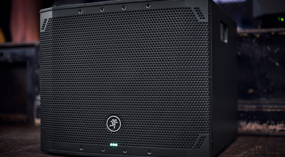Thumpv4 subwoofer on floor in front of stage viewed from angle.